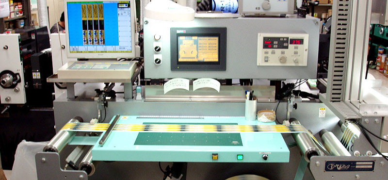 シール印刷の自動検査機で仕上がりをチェックしています